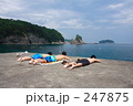 堤防で寝そべる少年