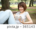 公園のベンチで本を読む女性