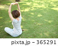芝生の上でヨガをする女性