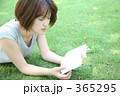 芝生の上で本を読む女性
