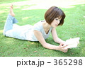 芝生の上で本を読む女性