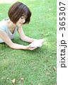 芝生の上で本を読む女性