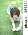芝生の上で本を読む女性