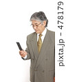 携帯電話でメールをするシニアのビジネスマン