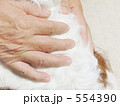 犬を撫でるシニアの手