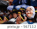 祭りでみこしを担ぐ男性とひょっとこ
