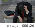 ベンチに座って悩む中年男性