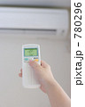 冷房を28℃に設定する女性の手