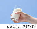 ドリンク（牛乳）を持つ女性の手と空