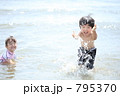 海水浴で水をかける幼い兄弟