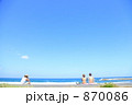 防波堤に座って海を眺める水着の女性