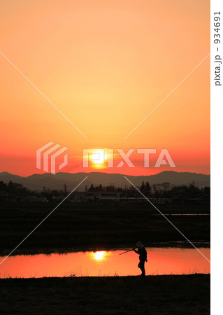 「夕日と農夫」の写真素材