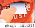 赤いポストに手紙を投函する