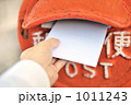 赤いポストに手紙を投函する
