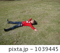 女の子が芝生の上で大の字に寝転んでいる