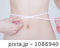 ウエストのサイズを測る女性のお腹