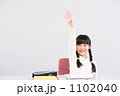 手を挙げる女の子(小学2年生)