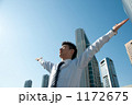 深呼吸をするビジネスマンと高層ビル