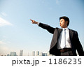 指をさすビジネスマンと高層ビル
