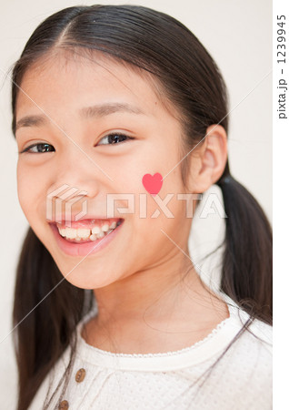 「ハートを頬に貼った女の子」の写真素材 「ハートを頬に貼った女の子」の写真素材