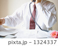 書類片手に電話で話すワイシャツ姿のサラリーマン