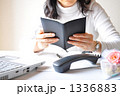 受話器を置きスケジュールを確認するビジネスウーマン