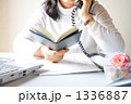 電話で話しながらスケジュールを確認するビジネスウーマン