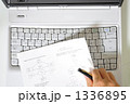 パソコンと英語の資料を持つ手