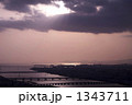薄紅色の夕景の中で川面と海面を照らす光芒