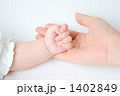 赤ちゃんの手を包む母親