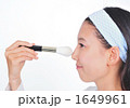 女性とチークブラシ