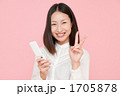 ケータイを持ってピースする女性
