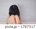 顔を伏せて座る少女
