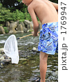 川で魚とりをする少年