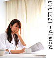 朝食を食べながら新聞を読む女性