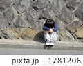 膝を抱えて座る子供