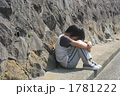 膝を抱えて座る子供