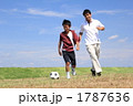 広場でサッカーをする親子
