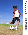 広場でサッカーをする男の子