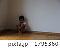 膝を抱えて座る男児
