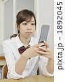 携帯電話を見る女子高生