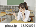 携帯電話を見る女子高生