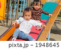 滑り台を降りる1歳の女の子たち