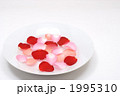 皿と水の上に浮かぶバラの花びら