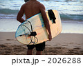 夕方の海に向かうサーファー