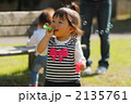 シャボン玉で遊ぶ1歳の女の子
