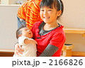 7歳のお姉ちゃんの腕に抱っこされる赤ちゃん