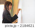 黒板に文字を書く女子高生