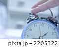 目覚まし時計を止める女性の手元