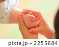 幼いお姉ちゃんの手が赤ちゃんの手を包む